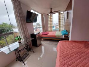 a bedroom with a bed and a tv and a window at Villa Del Solar in Asia