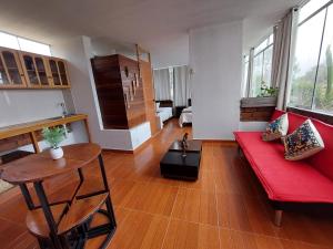 a living room with a red couch and a table at Villa Del Solar in Asia