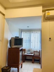 a living room with a tv and a table at Wiriya House in Chiang Mai