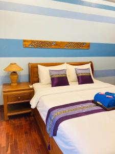 twee bedden in een slaapkamer met een blauw-witte muur bij Wiriya House in Chiang Mai