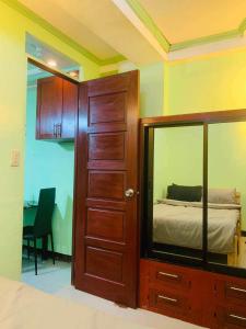 1 dormitorio con espejo, cama y puerta en Casa De Familia Staycation, en Manila