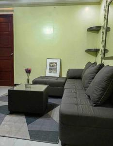 een woonkamer met een bank en een salontafel bij Casa De Familia Staycation in Manilla