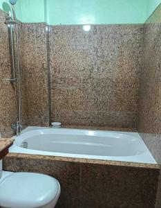 a bathroom with a bath tub and a toilet at Casa De Familia Staycation in Manila