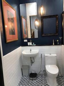 a bathroom with a white toilet and a sink at THE OAK’S in Chiang Rai