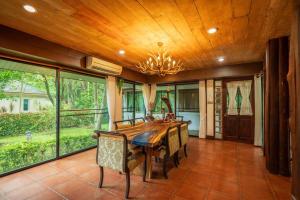 - une salle à manger avec une table et des chaises en bois dans l'établissement Khao Yai Log House, à Pak Chong