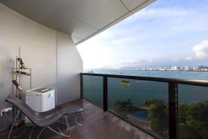 a balcony with a bench and a view of the ocean at Sanya Phoenix Island Yuejia flat in Sanya