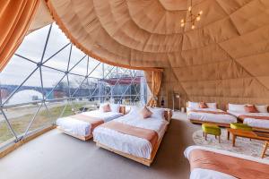 Shōbaraにある備北丘陵公園　湖畔ステイズ庄原のベッド3台、大きな窓が備わる客室です。