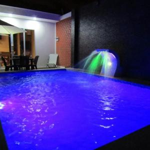 una piscina de agua con cascada en una habitación en MERINO HOUSE COLAN BEACH, en Paita