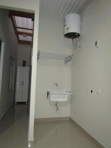 ein Bad mit einem Waschbecken und einer Lampe an der Wand in der Unterkunft MERINO HOUSE COLAN BEACH in Paita