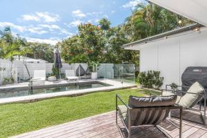 a patio with chairs and a pool in a backyard at Pool House - Peaceful Luxury, Byron Bay in Byron Bay