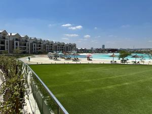 - Vistas a un complejo con césped y piscina en Cosy Munyaka Waterfall Apartment, en Midrand