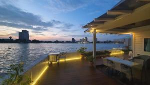 a deck with a view of the water at night at Riverfront house/Chao phraya river/Baan Rimphraya in Bangkok