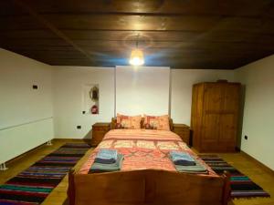ein Schlafzimmer mit einem großen Holzbett in einem Zimmer in der Unterkunft Къща за гости Близнаците in Leshten