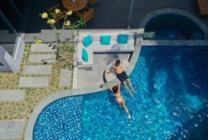 un hombre está en una piscina en Tropik Resort Lombok, en Selong Belanak