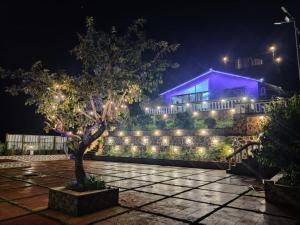 una casa con luces delante de ella por la noche en Hilltop Resort and Agro Tourism Wai, Near Panchgani en Wai