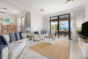 サンシャインビーチにある1 Craiglea Lodge Prime Location Right at the Beach Views Poolのソファとテレビのあるリビングルーム