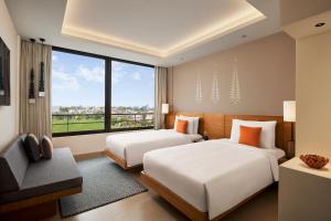 two beds in a room with a large window at Hyatt Place Bodh Gaya in Bodh Gaya