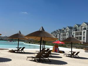 a group of chairs and umbrellas on a beach at Cosy Waterfall Midrand Apartment in Midrand