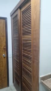a wooden closet with wooden blinds in a room at Angra inn, Angra dos Reis in Angra dos Reis