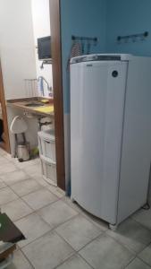 a white refrigerator in a kitchen with a table at Angra inn, Angra dos Reis in Angra dos Reis