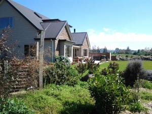 a house with a yard with bushes at Hadlow Sunrise Retreat in Timaru