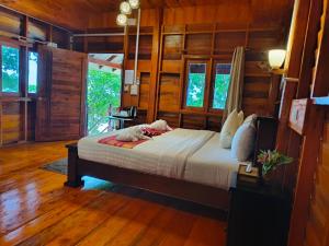 a bedroom with a bed in a room with wooden walls at Kohjum Seafront Resort in Ko Jum