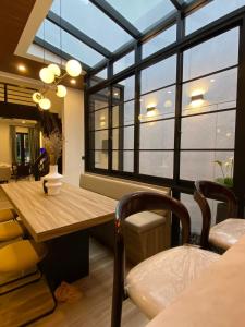 una sala da pranzo con tavolo e alcune finestre di Haha house a Padalarang