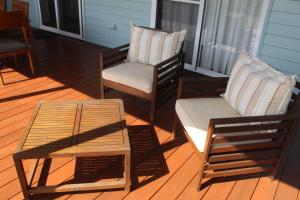 two chairs and a coffee table on a porch at Frog Hollow at Hat Head - 3 Oak Street in Hat Head +3 photos