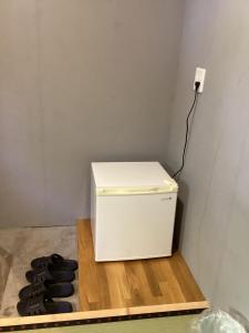 a white refrigerator sitting on a wooden shelf next to a stove at Sana Inn Town in Wakayama