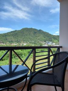 a balcony with two chairs and a view of a mountain at Aloha Residence in Kata Beach