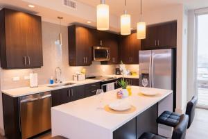 Luxurious & cozy 2bedroom/2bath apt downtwn Dallas في دالاس: مطبخ مع كونتر ابيض وثلاجة