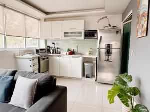 a kitchen with white cabinets and a stainless steel refrigerator at Beautiful Apartment, Airport, Downtown, Foro Sol in Mexico City