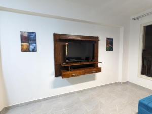 fully finished, very cozy and comfortable studio في بورت غالب: غرفة معيشة مع تلفزيون بشاشة مسطحة على جدار