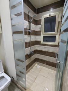 baño con ducha y TV. en fully finished, very cozy and comfortable studio -Marina city Residence, en Port Ghalib