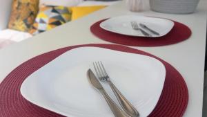 un plato blanco con un tenedor y un cuchillo en una mesa en Moderno e Reformado Studio em Copacabana, en Río de Janeiro