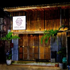 a building with a sign on the front of it at Rinvada House in Bangkok