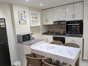 ポート・ガリブにあるfully finished, very cozy and comfortable studio -Marina city Residenceのキッチン(白いキャビネット、大理石のカウンタートップ付)