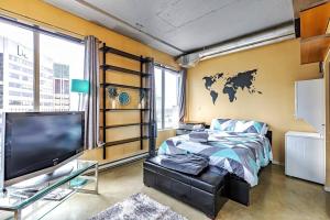 - une chambre avec un lit et une télévision dans l'établissement Industrial-Style Cityscape 1 Bedroom Loft, à Edmonton