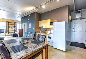 cocina con mesa y nevera blanca en Industrial-Style Cityscape 1 Bedroom Loft, en Edmonton