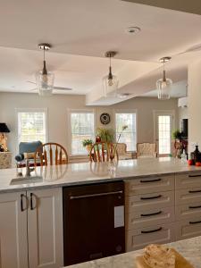 cocina con armarios blancos y encimera en Runaway Bay Guest House, en Hillier