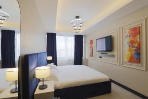 a bedroom with a bed with two lamps and a tv at Ravello Suites Taksim in Istanbul