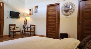 a bedroom with a bed and a table and a mirror at The Mystic Pines in Nainital
