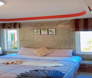 a bed on a boat with two windows at Popular Lanta Resort in Ko Lanta