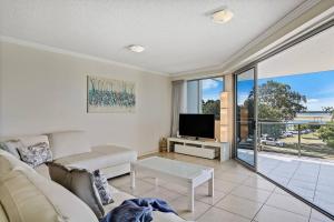 - un salon avec un canapé et une télévision dans l'établissement Modern Cotton Tree Apartment With Views, à Maroochydore