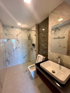 bagno con lavandino, doccia e servizi igienici di JIA HAUS Hotel Apartment a Buriram