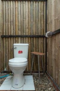 Des toilettes sont installées devant une clôture en bois. dans l'établissement Paddy Fields Haven - Natures Nest, à Pai