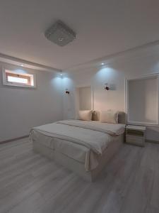 a white bedroom with a large bed in it at Hotel DARI-ZANJIR family guest house in Samarkand