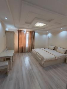 a bedroom with a large bed and a table and a desk at Hotel DARI-ZANJIR family guest house in Samarkand