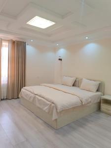 sypialnia z dużym łóżkiem w białym pokoju w obiekcie Hotel DARI-ZANJIR family guest house w Samarkandzie