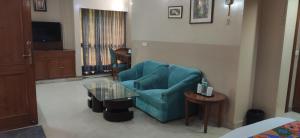 a living room with a blue couch and a table at HOTEL CONCLAVE EXECUTIVE in New Delhi